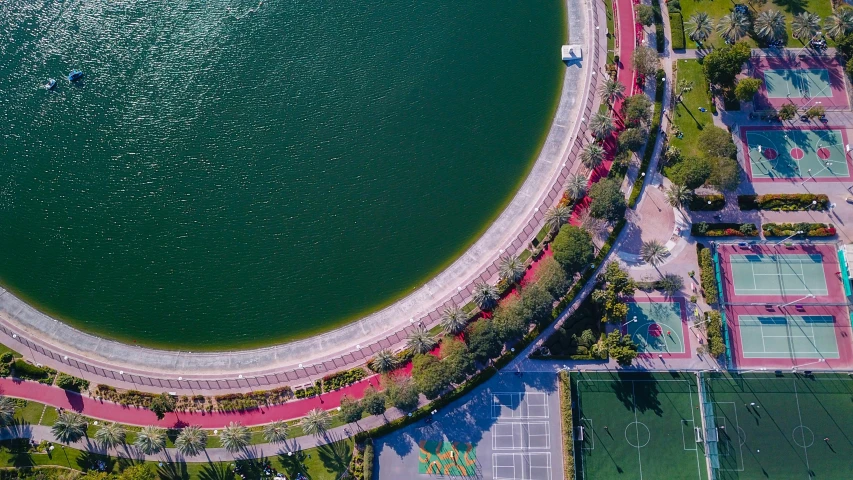 an aerial view of a tennis court next to a body of water, pexels contest winner, happening, circular shape, guangjian, a park, beautiful composition 3 - d 4 k
