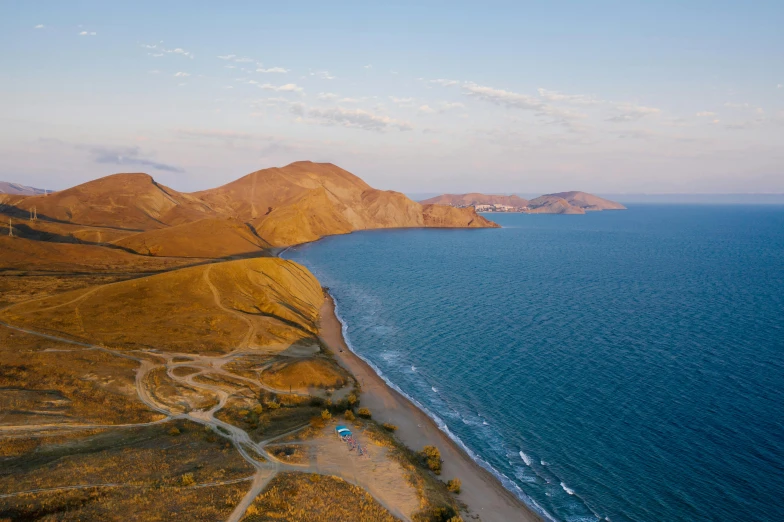 a large body of water next to a sandy beach, by Muggur, unsplash contest winner, near lake baikal, helicopter view, sunset beach, concert