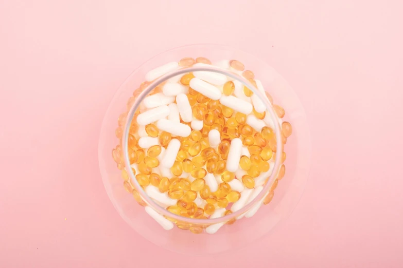 a bowl of cereal sitting on top of a pink surface, vials, bolts of bright yellow fish, detailed product image, liquid translucent amber