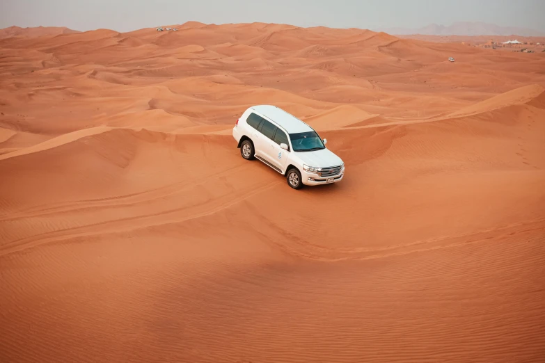 a white van is driving through the desert, by Julia Pishtar, pexels contest winner, hurufiyya, sheikh mohammed ruler of dubai, red sand, full car, dessert