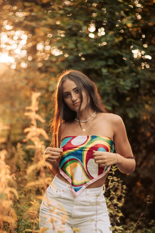 a woman standing in a field holding a heart, an album cover, by Julia Pishtar, trending on pexels, psychedelic swimsuit, colorful bandana, casual pose, summer night