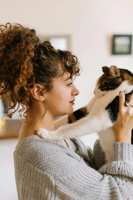 a woman holding a cat in her arms, trending on pexels, renaissance, calmly conversing 8k, at home, profile image, brunette