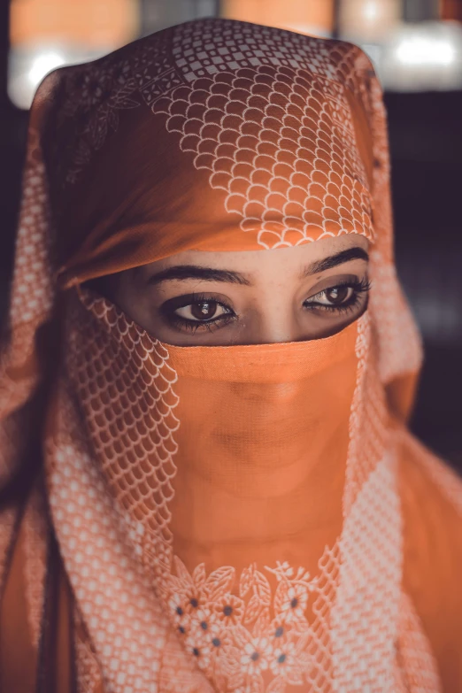 a close up of a person wearing a veil, a colorized photo, pexels contest winner, hurufiyya, orange and white, middle eastern, staring seductively, malaysian