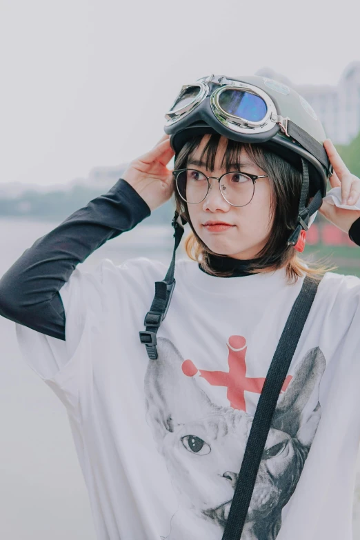 a woman standing next to a body of water wearing a helmet, a picture, inspired by Leng Mei, trending on unsplash, realism, girl wearing round glasses, japanese streetwear, wearing a t-shirt, male ulzzang