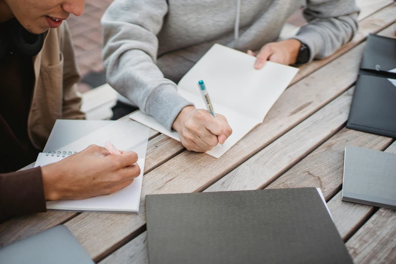 a couple of people sitting at a table with notebooks, pexels contest winner, academic art, instagram post, thumbnail, background image, ground level shot