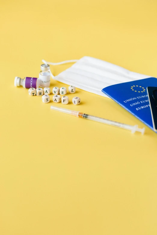 a passport and medical supplies on a yellow background, by Julia Pishtar, renaissance, syringe, on a white table, antibodies, thumbnail