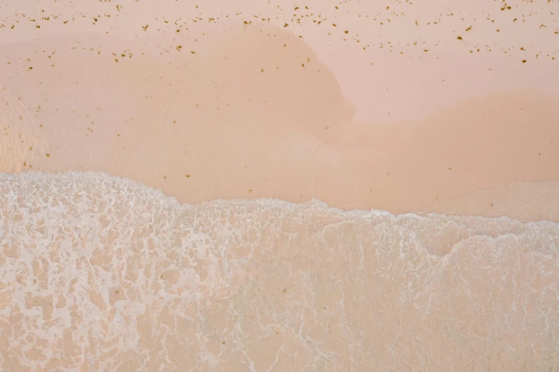 a person riding a surfboard on top of a sandy beach, by Carey Morris, unsplash contest winner, minimalism, covered in pink flesh, close-up from above, ochre, detailed water