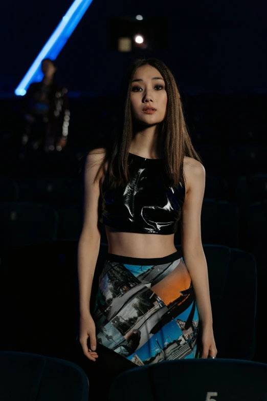 a woman in a black top and a colorful skirt, inspired by Zhang Shuqi, holography, standing in an arena, wearing a crop top, star wars film look, official store photo