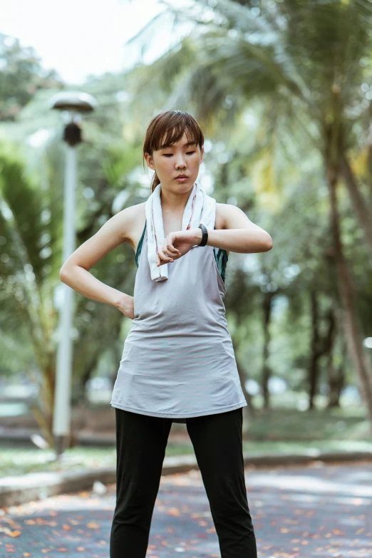 a woman standing on a skateboard in a park, inspired by Ruth Jên, unsplash, wearing : tanktop, vietnamese woman, dynamic stretching, worried