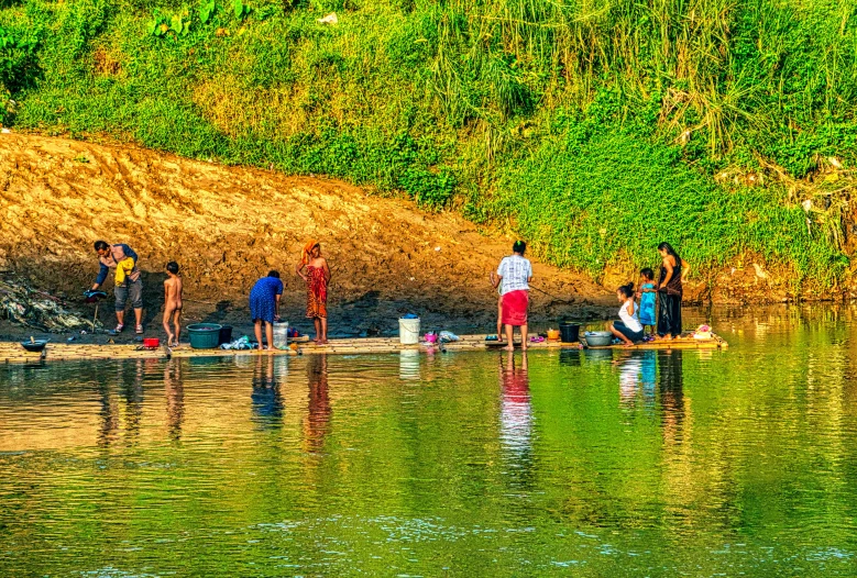 a group of people standing next to a body of water, by Jan Rustem, flickr, process art, laos, vivid colors!!, people on a picnic, late afternoon sun