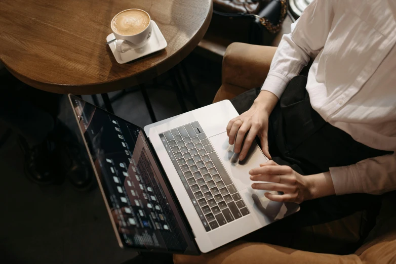 a person sitting at a table with a laptop, by Carey Morris, trending on pexels, sitting on a mocha-colored table, highly polished, thumbnail, coding