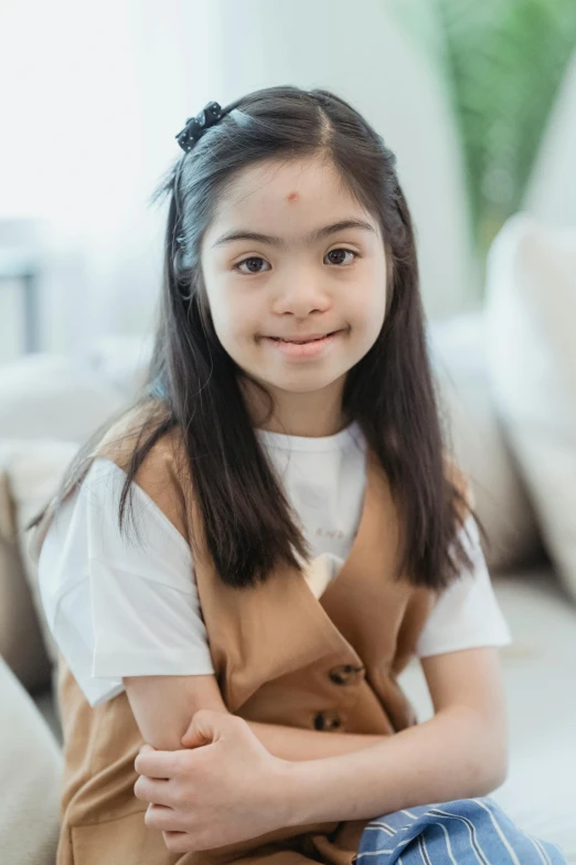 a little girl sitting on top of a couch, inspired by Elaine Duillo, pexels contest winner, dau-al-set, south east asian with round face, medium close-up shot, smiling confidently, portrait of white teenage girl