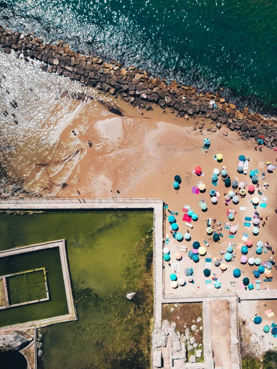 an aerial view of a beach with umbrellas and a tennis court, a picture, unsplash contest winner, 5 0 0 px models, group photo, looking at the ocean, today\'s featured photograph 4k