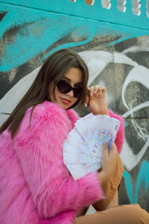 a woman in a pink fur coat holding a fan, inspired by Elsa Bleda, pexels contest winner, graffiti, money, :: madison beer, cash, mia khalifa