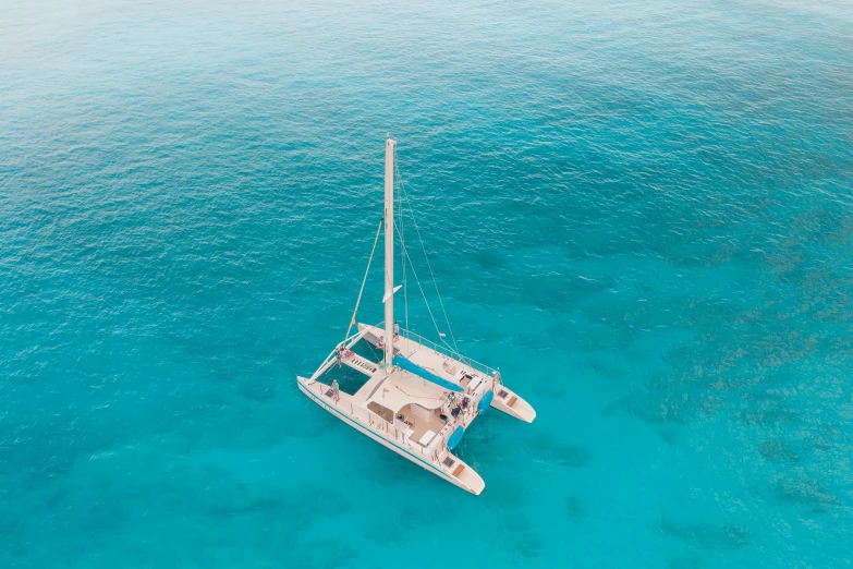 a catamaran in the middle of the ocean, looking down on the camera, vanilla, gazing at the water, cerulean