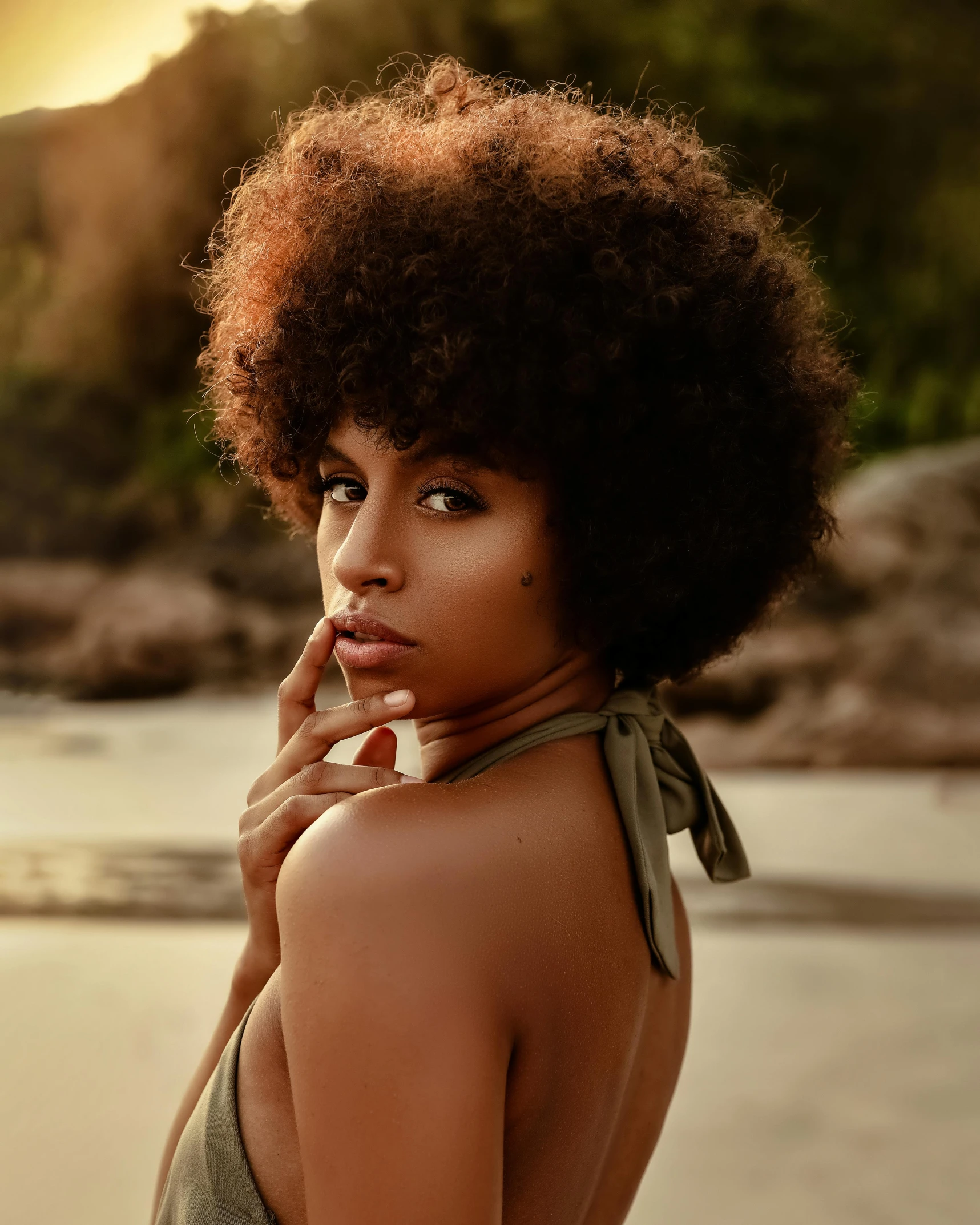 a woman standing on top of a beach next to the ocean, trending on pexels, afrofuturism, big hair, lovingly looking at camera, her skin is light brown, photo of a model