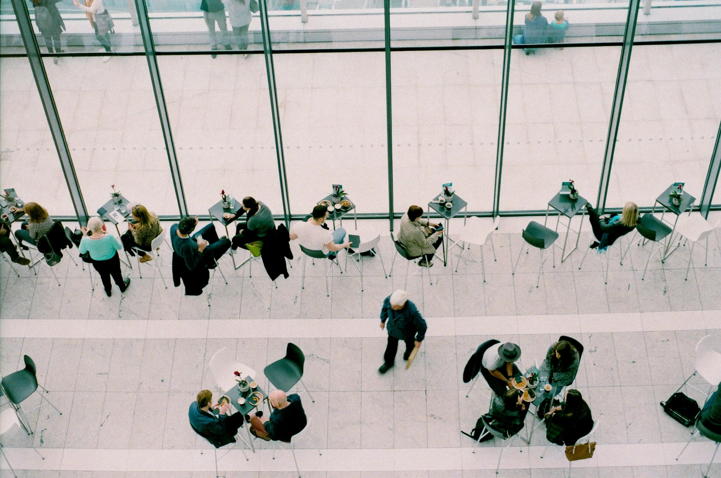 a group of people sitting at tables in a building, pexels contest winner, happening, looking down on the view, networking, promo image, thumbnail