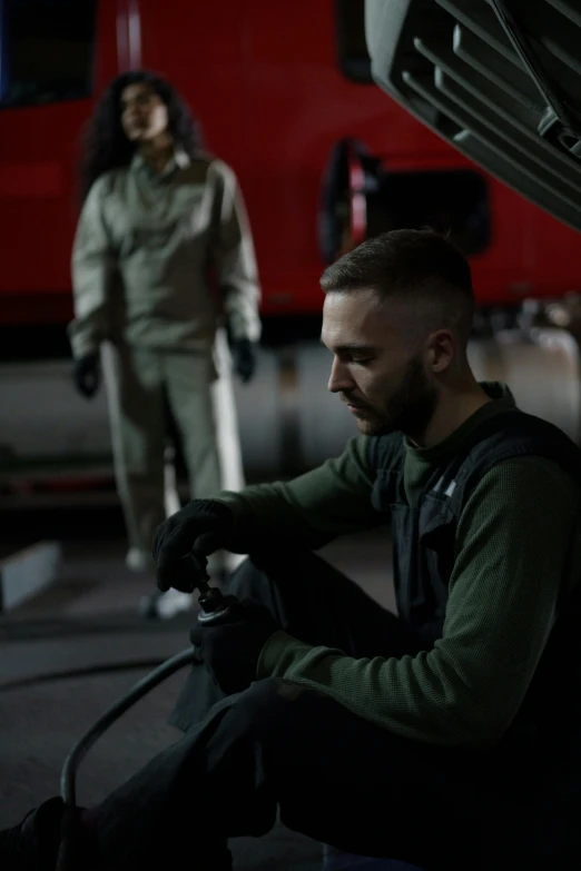 a man working on a car in a garage, inspired by Jóhannes Sveinsson Kjarval, military clothing, **cinematic, profile image