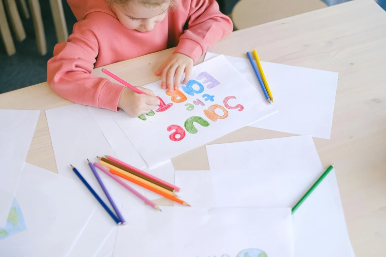 a little girl that is sitting at a table, a child's drawing, pexels contest winner, uppercase letter, full colour print, on white paper, art set