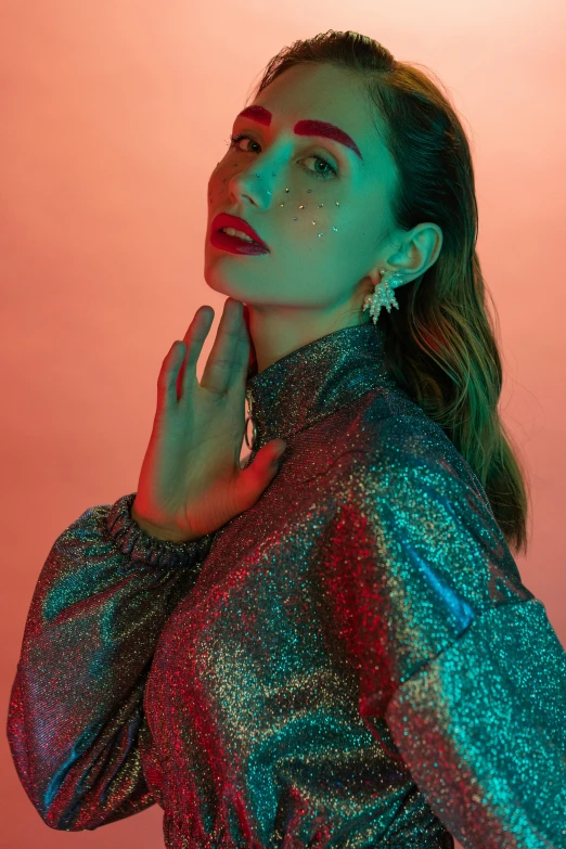 a woman standing in front of a pink background, an album cover, inspired by Elsa Bleda, trending on pexels, holography, red and blue back light, ana de armas portrait, glitter, wearing a fancy jacket