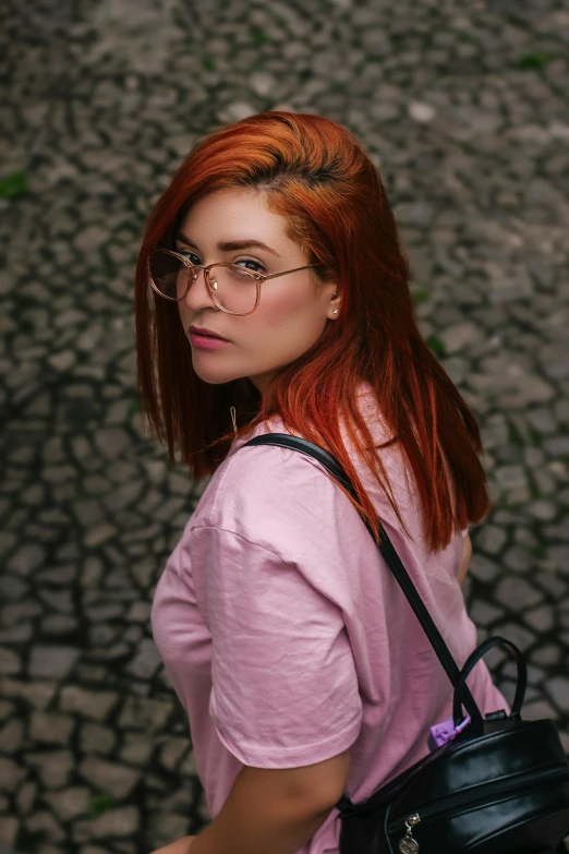 a woman with red hair walking down a cobblestone street, inspired by Elsa Bleda, pexels contest winner, renaissance, square rimmed glasses, attractive young woman, pink glasses, color photo