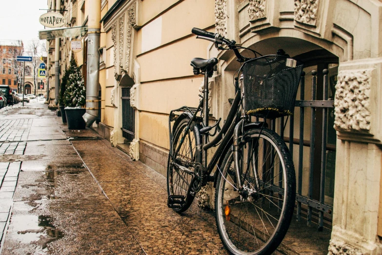 a bicycle parked on the side of a building, pexels contest winner, art nouveau, wet sidewalk, helsinki, profile image