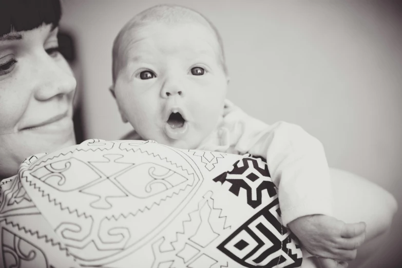 a woman holding a baby in her arms, a black and white photo, shutterstock contest winner, pop art, surprised, sharpie, lachlan bailey, adorable design