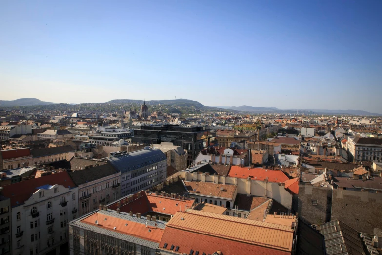 a view of a city from the top of a building, inspired by Jenő Gyárfás, square, blue sky, cleanest image, slide show