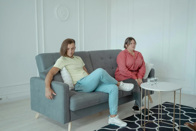 two women sitting on a couch in a living room, by Adam Marczyński, pexels contest winner, hyperrealism, slightly overweight, sad man, full body 8k, video footage