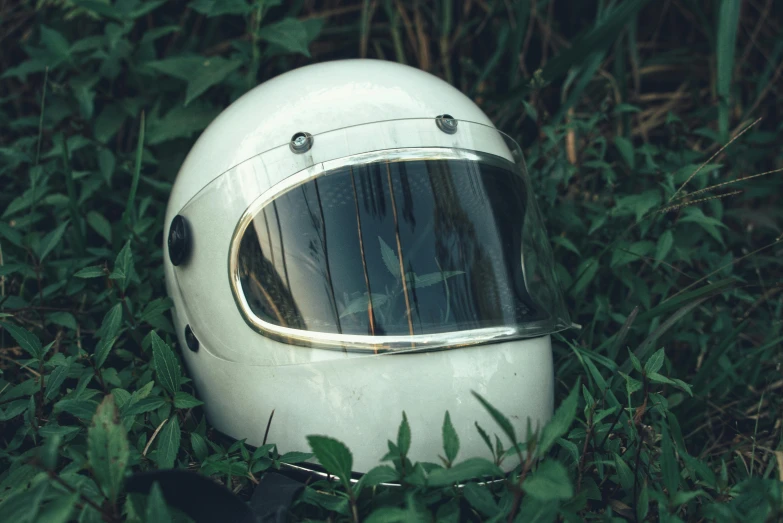 a helmet that is sitting in the grass, inspired by Elsa Bleda, unsplash contest winner, retrofuturism, portrait of astronaut, cafe racer, instagram picture, glossy white metal