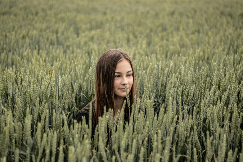 a woman standing in a field of tall grass, a picture, pexels contest winner, with neat stubble, teenager girl, few farm green highlights, avatar image