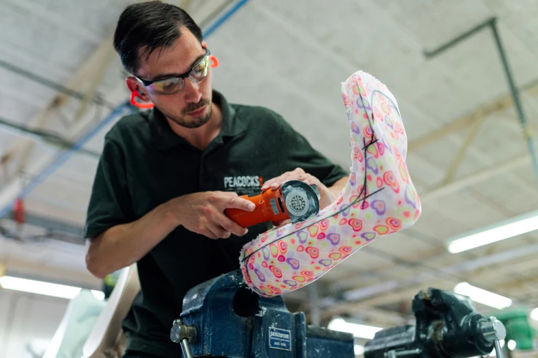 a man working on a machine in a factory, pexels contest winner, photorealism, inflatable future shoes, made of fabric, patterned, alana fletcher