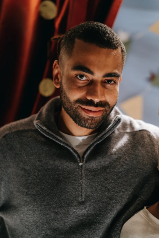 a man holding a nintendo wii game controller, a character portrait, inspired by Oluf Høst, pexels contest winner, hurufiyya, wearing a dark sweater, a portrait of rahul kohli, smiling seductively, portrait photo