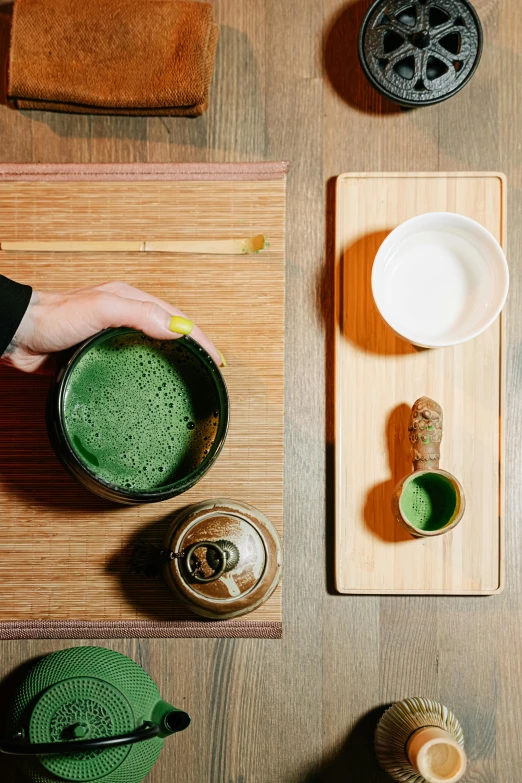 a person holding a cup of green tea, a still life, inspired by Gatōken Shunshi, trending on unsplash, on a wooden tray, powder, wide angle”, juice