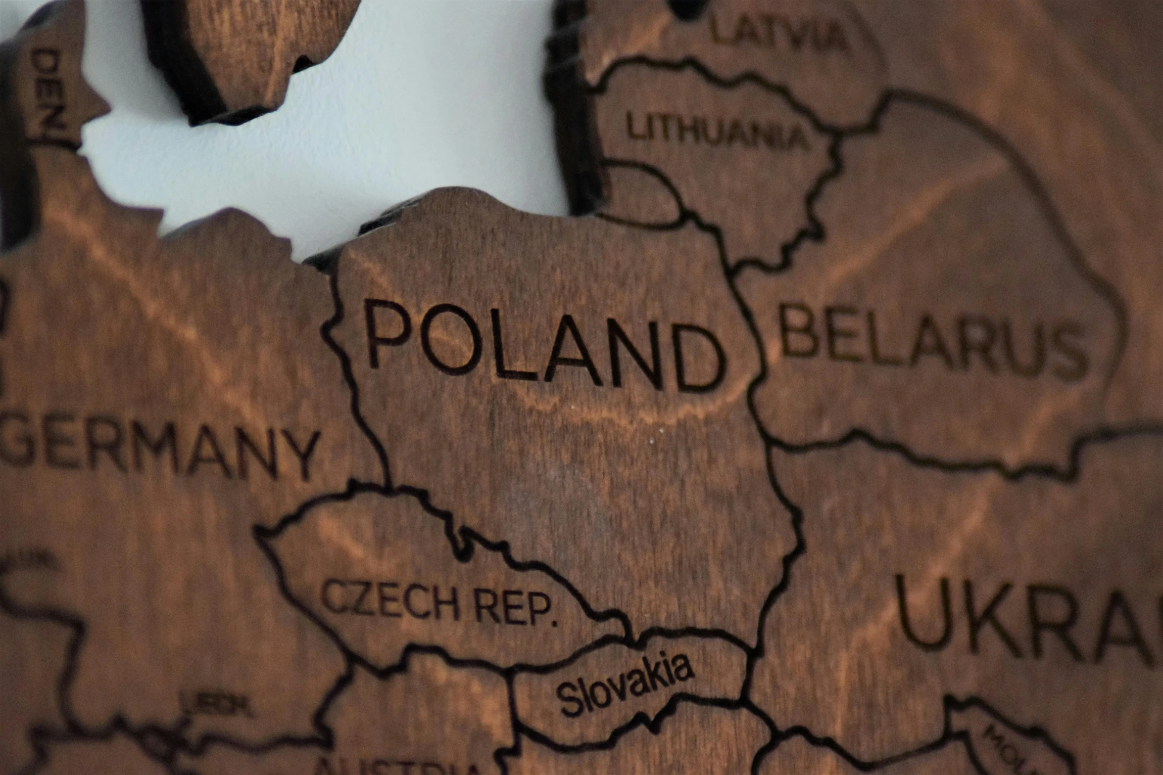 a close up of a piece of wood with a map on it, by Adam Marczyński, pexels, socialist realism, poland, modeled, each land is a different color, brown hair in a ponytail