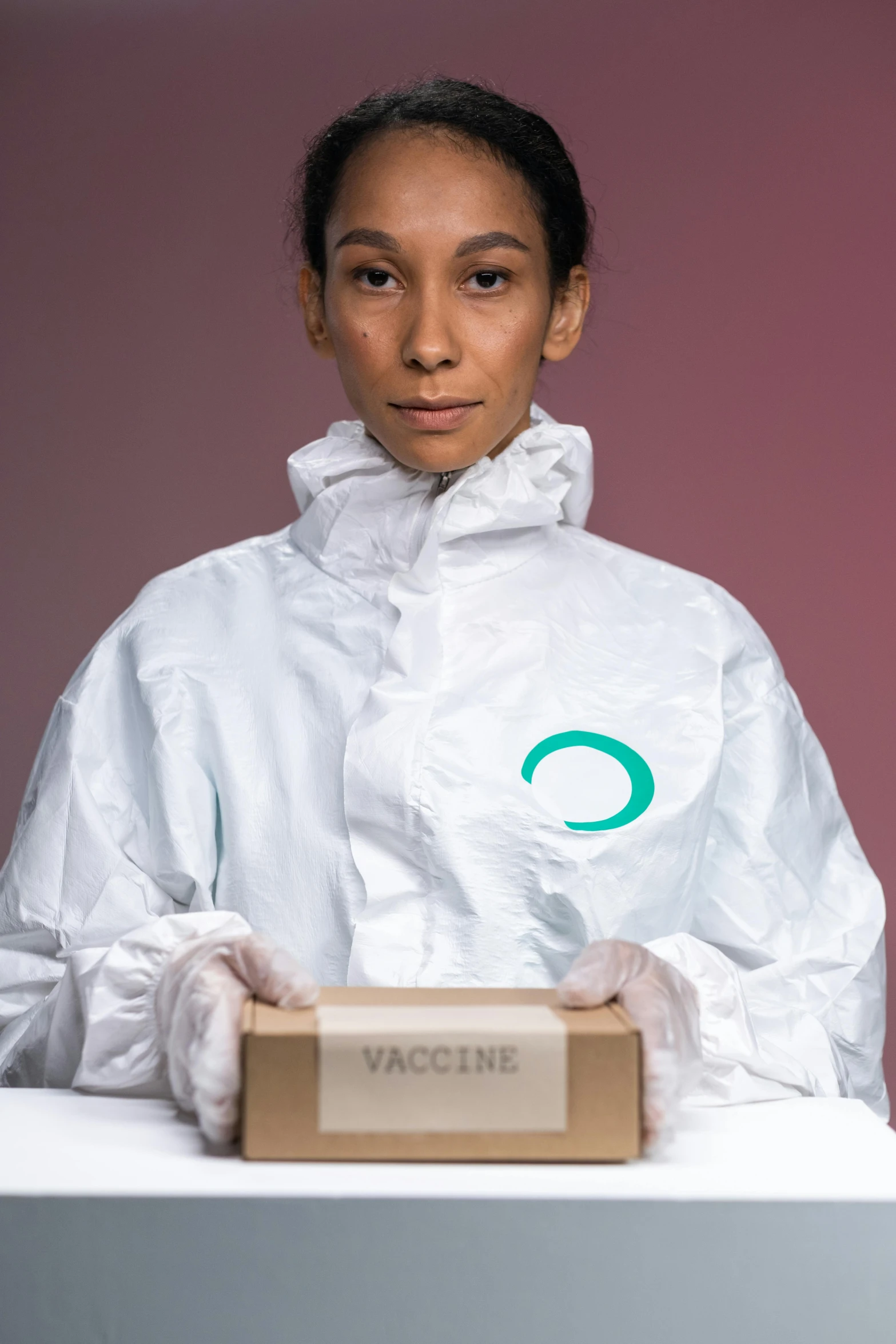 a woman in a protective suit holding a box, inspired by Jan de Baen, pexels contest winner, white and teal garment, vials, asian man, mit technology review