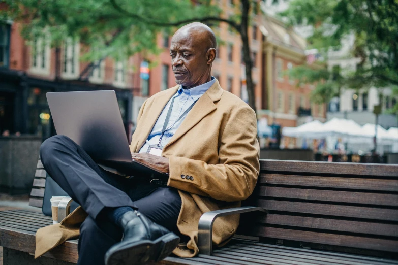 a man sitting on a bench using a laptop, inspired by William H. Mosby, pexels contest winner, renaissance, humans of new york style, african canadian, middle - age, thumbnail