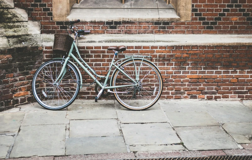 a bicycle parked in front of a brick building, pexels contest winner, arts and crafts movement, sage green, college, profile image