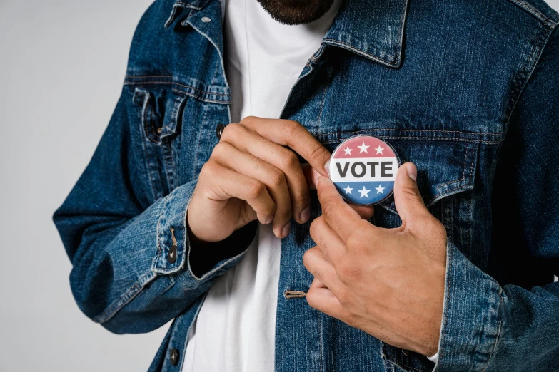 a man putting a vote button on his jacket, a photo, trending on pexels, renaissance, wearing a t-shirt, wearing denim, thumbnail, cutout