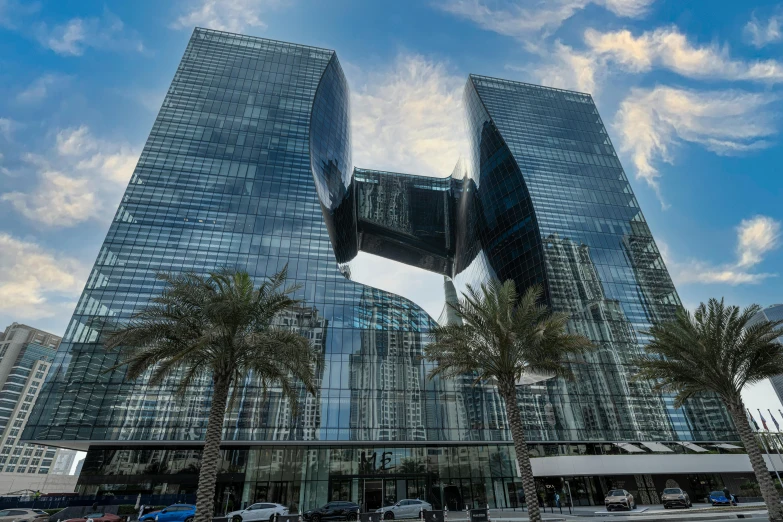 a very tall building with palm trees in front of it, inspired by Zaha Hadid, pexels contest winner, morphosis, dubai, buildings covered in black tar, thumbnail