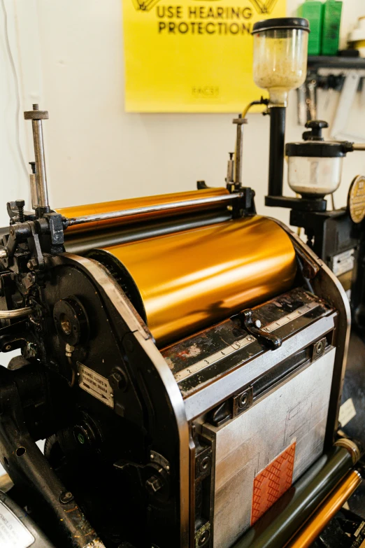 a machine that is sitting in a room, a silk screen, gold and black metal, vintage colours, a close up shot, exterior shot