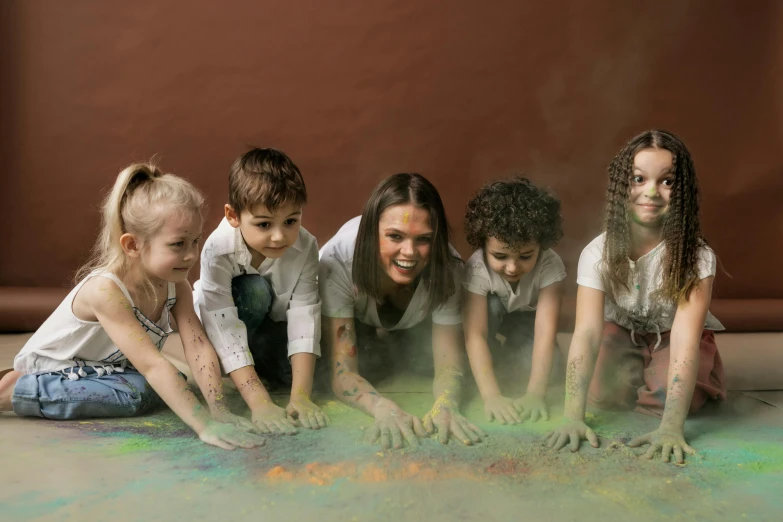 a group of children playing with colored powder, interactive art, sandy colours, school curriculum expert, portrait image