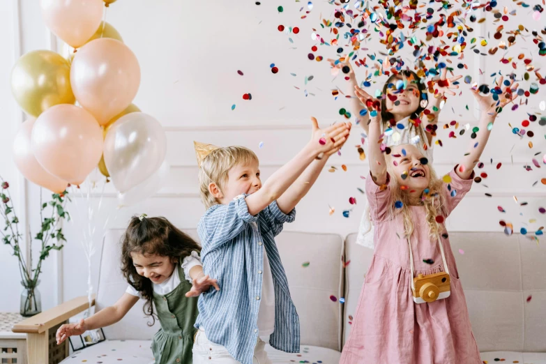 a group of children playing with balloons and confetti, by Emma Andijewska, pexels contest winner, decoration around the room, white background, laughing, background image