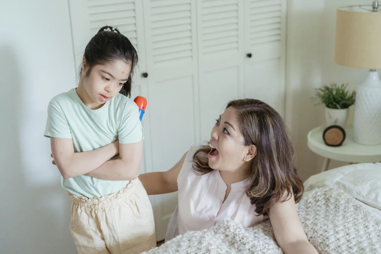 a woman standing next to a little girl on a bed, a cartoon, pexels contest winner, screaming in pain, asian female, holding a cane, teenage no