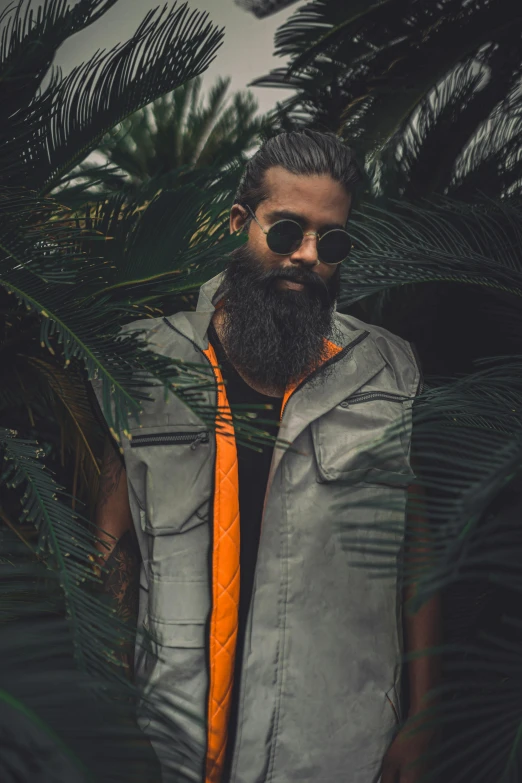 a man with a beard wearing an orange tie, an album cover, by Byron Galvez, pexels contest winner, lush foliage, model is wearing techtical vest, wearing shades, metal garments