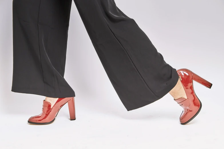 a close up of a person wearing high heels, by Nina Hamnett, arabesque, red shirt brown pants, patent style, lena oxton, half turned around