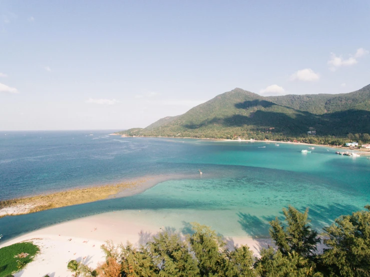 a large body of water next to a beach, by Aguri Uchida, unsplash contest winner, mingei, lush paradise, vietnam, slightly tanned, nezha