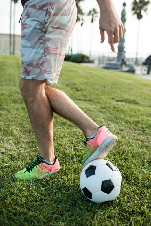 a man is kicking a soccer ball on the grass, by Jan Tengnagel, trending on dribble, foot wraps, athletic shorts, lgbtq, lynn skordal