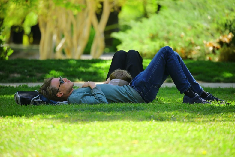 a man laying on top of a lush green field, profile image, parks and gardens, well shaded, two exhausted