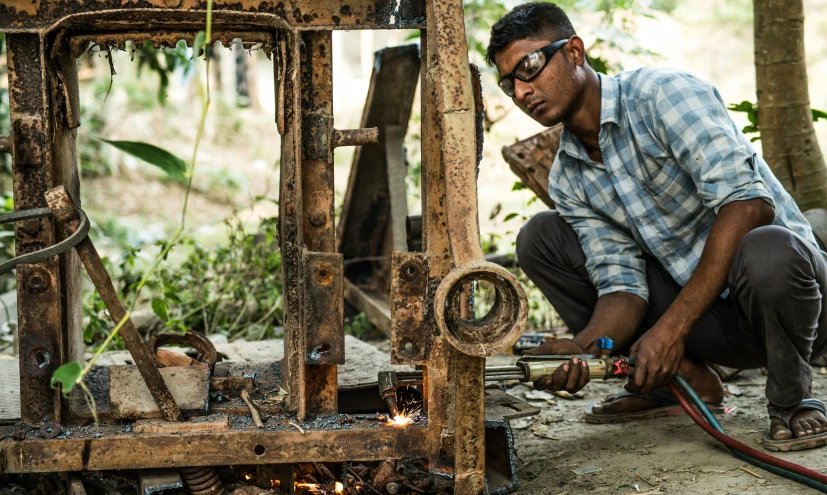 a man that is kneeling down with a hose, pexels contest winner, auto-destructive art, with vestiges of rusty machinery, single bangla farmer fighting, avatar image, woodlathe
